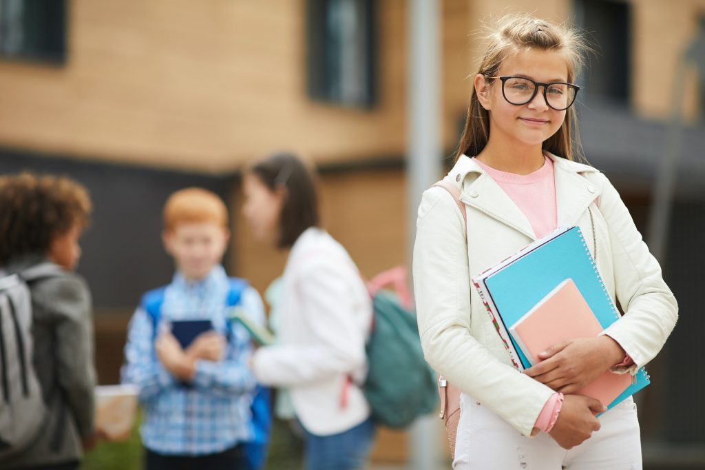 Schoolgirl with books at school